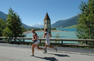 Die Laufstrecke führt vorbei am Wahrzeichen des Reschensees – dem fast versunkenen Kirchturm von Graun im Vinschgau. Bildnachweis: Gerald Burger