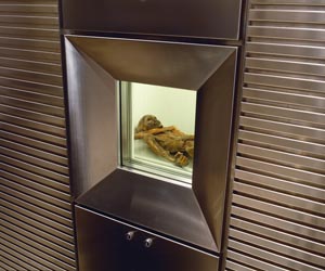 Für den Mann aus dem Eis wurde ein weltweit einzigartiges Kühlsystem entwickelt, das es erlaubt, die Mumie der Öffentlichkeit zu zeigen. Um den Feuchtigkeitsverlust des Ötzi zu verhindern, wird sie mit Wasser bespritzt, so dass sich an der Oberfläche eine feine Eisschicht bildet. Das Bild zeigt das Vitrinenfenster zur Kühlzelle der Mumie. - Foto: Südtiroler Archäologiemuseum